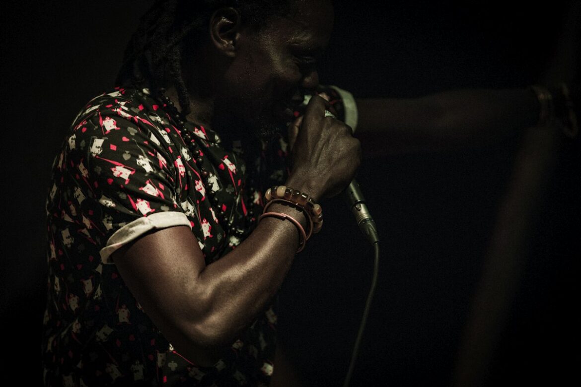 Illustrative image of a vocalist performing on stage; this is not a photograph of Fireboy DML.